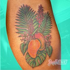 a close up of a tattoo on a person's leg with fruit and leaves