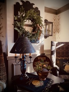 a table topped with two lamps next to a christmas wreath on top of a chair