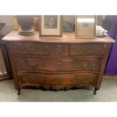 an old wooden dresser with pictures on top