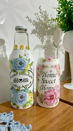 two glass bottles sitting on top of a wooden table