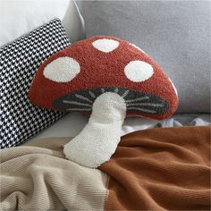 a mushroom shaped pillow on top of a bed