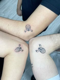 two people with matching tattoos on their legs sitting next to each other in the bed