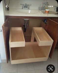 a bathroom sink with two open drawers underneath the faucet in front of it