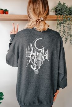 Stay warm and stylish with this Hogwarts Castle themed Sweater. Made from dark grey heather fabric, this soft and cozy garment is perfect for Harry Potter fans who want to represent the wizarding world in their style. Small Shirt Outfit, Harry Potter Tshirt Ideas, Hogwarts Sweater, Outfit Ideas Shirt, Harry Potter Sweater, Harry Potter Hoodie, Universal Studios Outfit, Shirt Outfit Ideas, Shirt Design Ideas