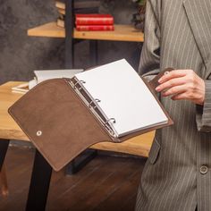 a woman holding a binder in her hand