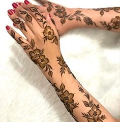 a woman's hands with hennap and flowers on them