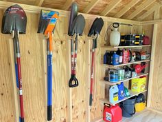 the inside of a shed with tools and cleaning supplies on shelves, including shovels