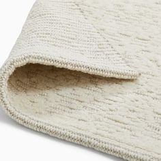 a close up view of a white rug on a white surface with an open end