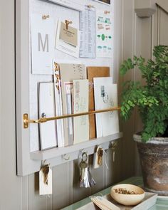 a potted plant sitting on top of a table next to a wall mounted calendar