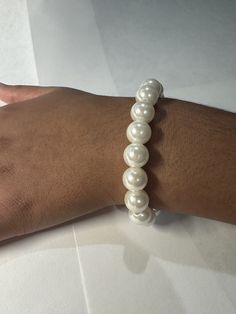 Beautifully handmade white imitation pearl bracelet. Elegant White Beaded Bracelets With 8mm Beads, Elegant Pearl White Stretch Bracelet As A Gift, White Pearl Drop Bracelet For Party, Pearl White Bracelets With Pearl Drop For Party, Adjustable Pearl Drop Bracelets For Parties, Classic White Beaded Bracelet, White Pearl Drop Bracelets For Party, Pearl White Bracelet With Pearl Drop For Party, Formal White Beaded Bracelets With Pearl Charm