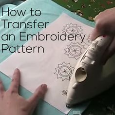 a person is using a sewing machine to make an embroidery pattern on a piece of paper