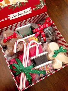 a box filled with assorted cookies and candy canes on top of a wooden table