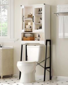 a white toilet sitting in a bathroom next to a cabinet filled with books and other items