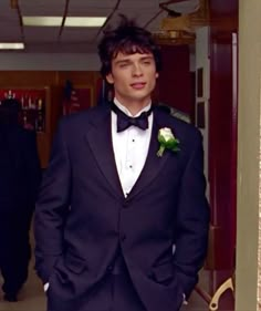 a young man in a tuxedo is looking at the camera