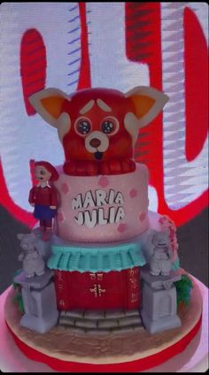 a red and white cake sitting on top of a table next to a tv screen