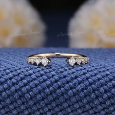 a pair of gold and diamond rings sitting on top of a blue blanket in front of a stuffed animal