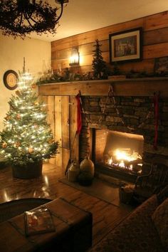 a living room with a christmas tree and fire place in the corner, surrounded by holiday decorations