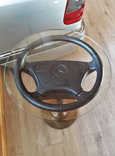 a car steering wheel on top of a glass table