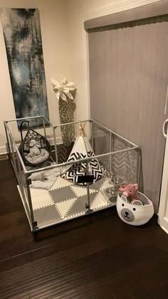 a baby crib in the corner of a room with a teddy bear and other items