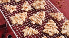 some cookies are cooling on a rack with white icing and sprinkles