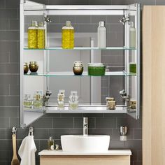 a bathroom sink sitting under a mirror next to a shelf filled with soap and lotion