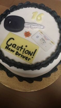 there is a cake that says caution new driver on the top and yellow stickers on the bottom