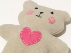 a white teddy bear with a pink heart on it's back and its eyes closed