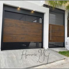 two large brown garage doors in front of a white house with palm trees on the side