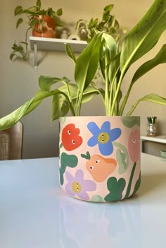 a potted plant sitting on top of a white table next to a green plant