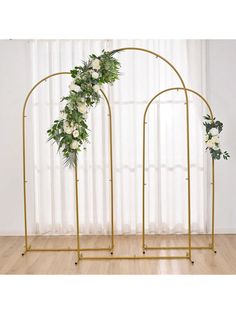 two gold arches with white flowers and greenery