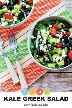 two bowls filled with greek salad on top of a table next to a fork and knife