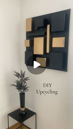 a plant is sitting on a small table in front of a wall hanging art piece that says diy upcycling