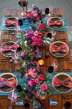 the table is set with pink and purple flowers