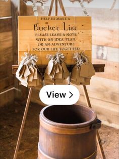 a wooden bucket sitting on top of a table next to a sign that says, help us make a bucket list please leave a note for an adventure or an adventure for our life together