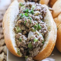 a close up of a sandwich with meat and veggies in it on a plate