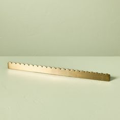 a metal bar that is on top of a table next to a white wall with a green background