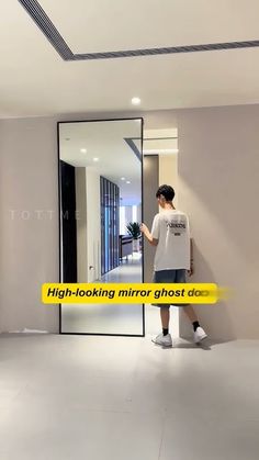 a man standing in front of a mirror with the words high - looking mirror ghost decal on it