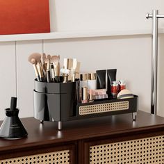 an assortment of makeup brushes on top of a dresser