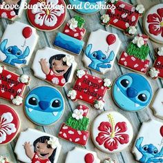 some decorated cookies are on a table with flowers and other items in the shape of cartoon characters