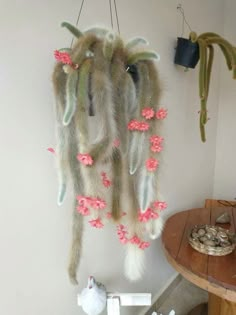 a wall hanging with flowers and feathers in the shape of an animal's head