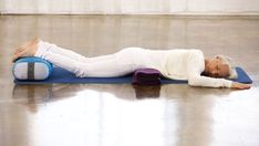 a woman laying on top of a blue mat