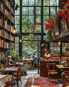 people sitting at tables in a library with lots of bookshelves and plants hanging from the ceiling