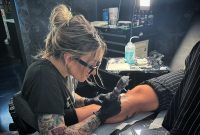 a woman getting her tattoo done at a salon