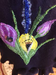 the back of a black jacket with purple flowers on it