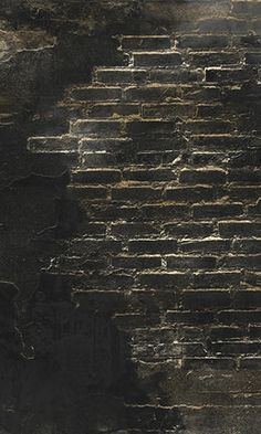 an old black brick wall with white paint