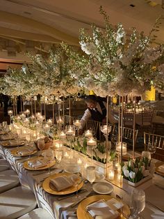 a long table is set with candles and flowers for an elegant dinner or reception event