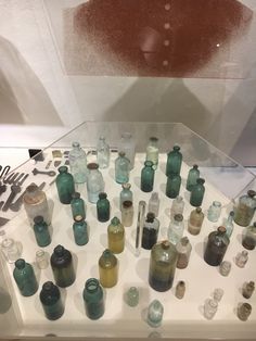 there are many glass bottles on display together