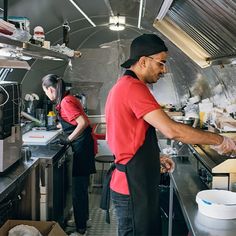 two people in a kitchen preparing food