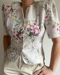 What a sweetheart! Vintage 80s blouse that can also work as a short blazer.  Fitted bodice, shoulder pads, V-neckline and hidden button down front closure. Adorable floral print in different shades of pink, green and yellow on beige vase. Perfect with your favorite skirts, denim or high waisted trousers.  Best Fits M depending on desired drape. Please refer to measurements. Shown on 5'8", 38-29-38 Measures approximately: 15" shoulder  to shoulder / 40" bust / 26" overall length / 11.5" sleeves / Fitted Blouse With Notched Neckline For Spring, Fitted Spring Blouse With Notched Neckline, Fitted Tops With Notched Neckline For Spring, Vintage V-neck Tops For Workwear, Retro V-neck Top For Workwear, Fitted Blouse With Buttons For Spring, Fitted Button Blouse For Spring, Feminine Fitted Blouse With Buttons, Fitted Spring Blouse With Buttons