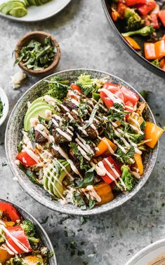 two bowls filled with different types of salads on top of a gray countertop